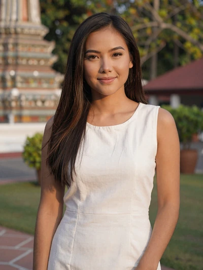 Nanthana, 30, Thai woman in white linen dress near a temple garden in Chiang Mai